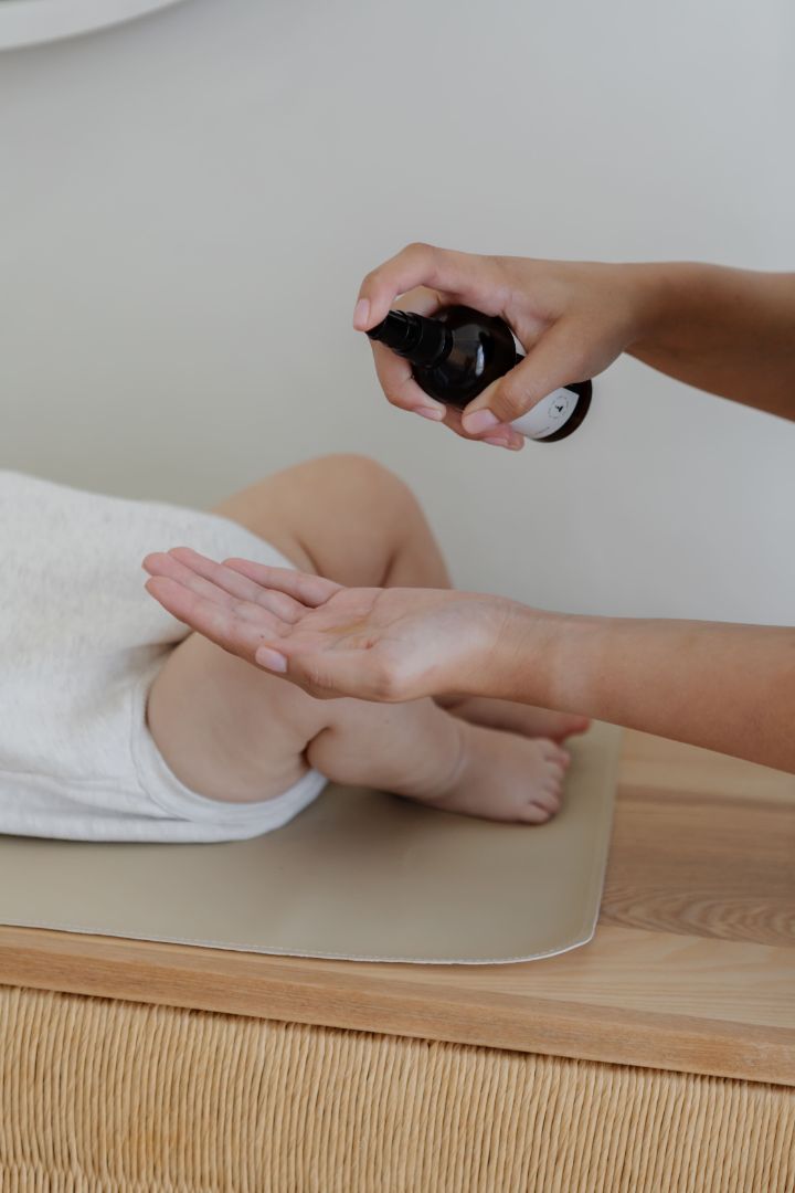 baby on change table with baby oil